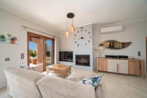 a living room with a couch and a clock on the wall at Villa Cleopatra Fiskardo in Fiskardho