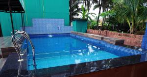 una gran piscina con azulejos azules en Vedana Retreat Arambol, en Arambol 25 fotos más