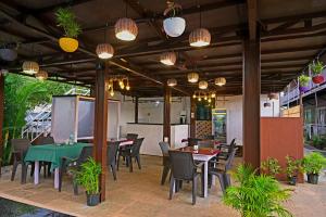 a patio with tables and chairs and lights at Vedana Retreat Arambol in Arambol