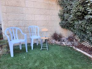 耶路撒冷的住宿－Best Home Jerusalem Holy Land Close to Everything Israel Gateway 4 families & individual，两把蓝色的椅子和一把凳子在草地上