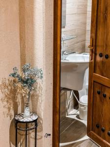 un bagno con lavandino e un vaso di fiori su un tavolo di Omani Guest House نزل البيت العماني a Nizwa Altre 37 foto