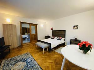 een slaapkamer met een bed en een tafel in een kamer bij Apartment Werkstatt Castelului in Braşov
