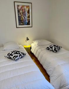 Zimmer mit 2 Betten und einem Tisch mit einer Lampe in der Unterkunft Alsalor in Gandrange