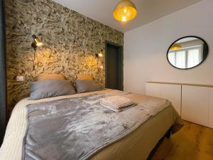 - une chambre avec un grand lit et un mur en pierre dans l'établissement "L'imprévue", 12 personnes dans la vieille ville !, à Boulogne-sur-Mer