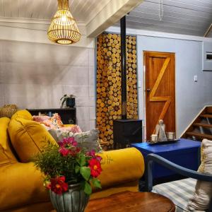 sala de estar con sofá amarillo y mesa en Glen Islay Cottage Himeville, en Himeville