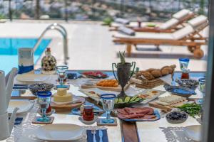 a table with food and drinks on a table near a pool at Contemporary Luxury Villa in Yalıkavak Center in Bodrum City
