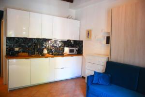a kitchen with white cabinets and a blue couch at Porta Romana Bella in Milan