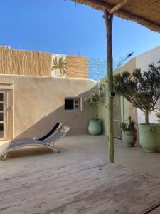 une chaise assise sur une terrasse avec un mur dans l'établissement Suite BELDI, La Maison des paons, à Sidi Kaouki