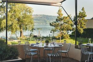 a patio with a table and chairs and a view of a lake at Hotel Bad Murtensee in Murten