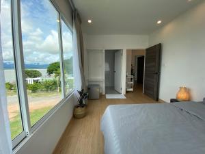 a bedroom with a bed and a large window at PB Place @ Kwan Payao in Phayao