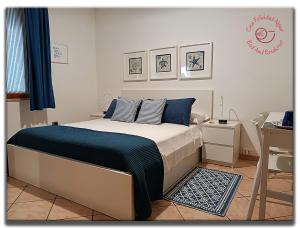a bedroom with a bed with blue and white sheets at Casa Felicidad Alguer B&B in Alghero