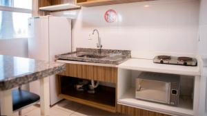 a kitchen with a sink and a microwave at LACQUA DI ROMA HOTEL in Caldas Novas