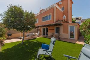 a house with a yard with chairs and a lawn at Luxury Villa y Ocean View in Santa Cruz de Tenerife