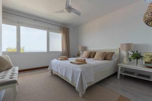 a white bedroom with a large bed and a window at Luxury Villa y Ocean View in Santa Cruz de Tenerife