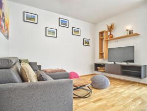 a living room with a couch and a flat screen tv at Sunlodge Oeblarn Top B1 Schladming-Dachstein in Öblarn