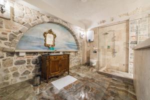 a stone bathroom with a sink and a shower at Casa Ra in Podgorica