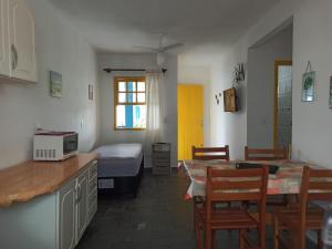 een keuken en eetkamer met een bed en een tafel bij CONDOMINIO COLONIAL APARTAMENTOS 150M DA PRAIA in Bombinhas
