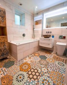 ein Badezimmer mit einer Badewanne, einem Waschbecken und einem WC in der Unterkunft Luxurious quirky flat in Greenwich O2 Arena with free parking in London