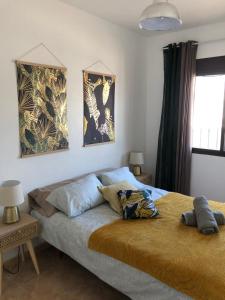 sypialnia z łóżkiem i 2 zdjęciami na ścianie w obiekcie L' Azotea del Sol appartement typique w mieście La Puebla