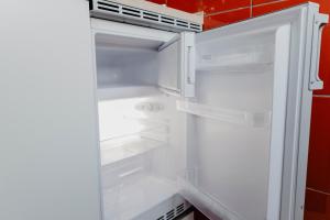 ゲルゼンキルヒェンにあるSK Apartments - Redのキッチンにあるドアが開いたままの空の冷蔵庫