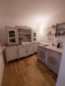 una cocina con armarios blancos y electrodomésticos blancos en Appart Aix sauna jacuzzi balneo spa privatifs hyper centre historique cour intérieur, en Aix-en-Provence