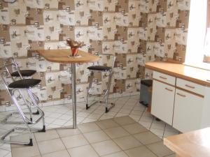 a kitchen with a table and stools in front of a wall of cardboard at Fewo im Neuseenland in Rötha