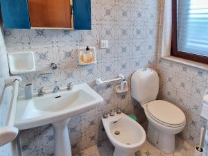 ein kleines Bad mit einem Waschbecken und einem WC in der Unterkunft Casa di Poseidone in Brucoli