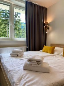 a bedroom with two white towels on a bed at Chata Tale - Dom Horskej služby in Tale