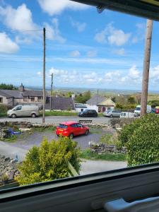 a view of a parking lot with a red car at Bryn Pistyll 2 bedrooms Bethesda in Llanllechid