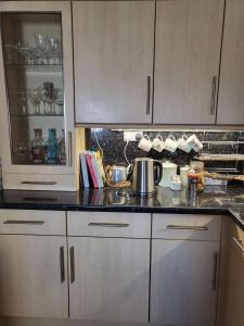 a kitchen with white cabinets and a counter top at Bryn Pistyll 2 bedrooms Bethesda in Llanllechid