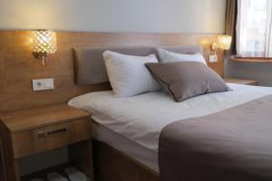 - une chambre avec un lit doté d'oreillers et d'une table de nuit dans l'établissement Adamantides Hotel, à Istanbul