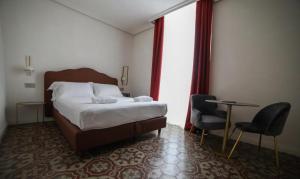 una camera d'albergo con letto, tavolo e sedie di 20 Miglia Boutique Hotel a Catania