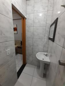 a white bathroom with a sink and a mirror at Motel reality in Sao Paulo