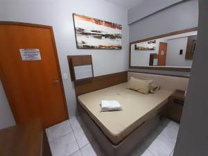 Habitación pequeña con cama y espejo. en Motel reality, en São Paulo