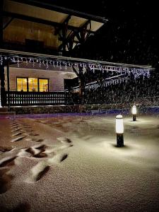 a stage with a light in the snow at night at Livada Bucovinei in Horodnic de Sus