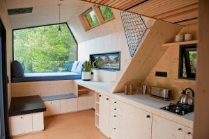 a kitchen in a tiny house with a large window at Tiny House Pioneer 5 - Green Tiny Village Harz in Osterode