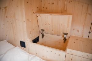 Zimmer mit einem Bett und einer Holzwand in der Unterkunft Tiny House Pioneer 5 - Green Tiny Village Harz in Osterode