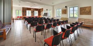 a room with rows of chairs and a podium at Albergo Casa Alpina San Luigi in Campodolcino
