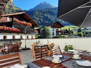 a patio with a table and chairs and a mountain at Ferienhaus Enzian in Prägraten
