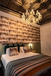 a bedroom with a large bed and a chandelier at Lace Market Hotel in Nottingham