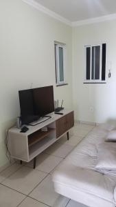 Cette chambre blanche dispose d'un bureau et d'une télévision à écran plat. dans l'établissement Apto com Varanda no N Bandeirante , proximo ao Aeroporto, à Brasilia