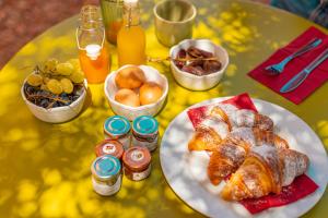 una mesa con un plato de cruasanes y otros productos para el desayuno en Villa Totò Resort en Cefalù