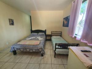 um pequeno quarto com duas camas e uma mesa em Espaço La Gondola em Araruama