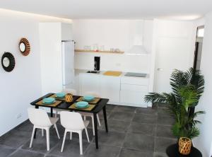 een keuken met een zwarte tafel en witte kasten bij Las Norias Apartamentos & Grill in Tazacorte