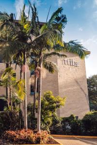 a building with palm trees in front of it at Tribe Hotel, Nairobi, a Member of Design Hotels in Nairobi