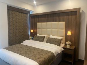 een slaapkamer met een groot bed met een houten hoofdeinde bij Hotel Cataleya in Almere