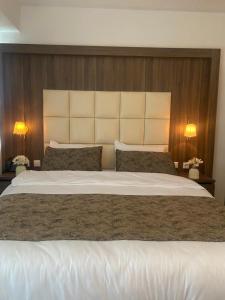 a large white bed in a bedroom with two lamps at Hotel Cataleya in Almere