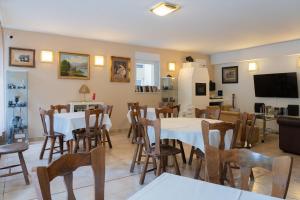 une salle à manger avec des tables, des chaises et une télévision dans l'établissement BALATONAIR Vendégház, à Balatonfüred