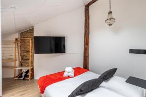 - une chambre avec un grand lit et une télévision murale dans l'établissement LE SAINT LOUIS - Apt 3 chambres au cœur de Rennes, à Rennes