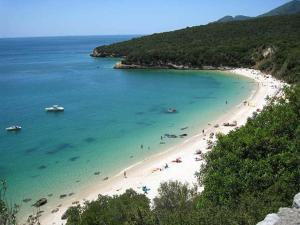 a beach with a bunch of people in the water at AL Florence in Setúbal